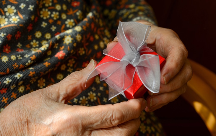 senior holding a present